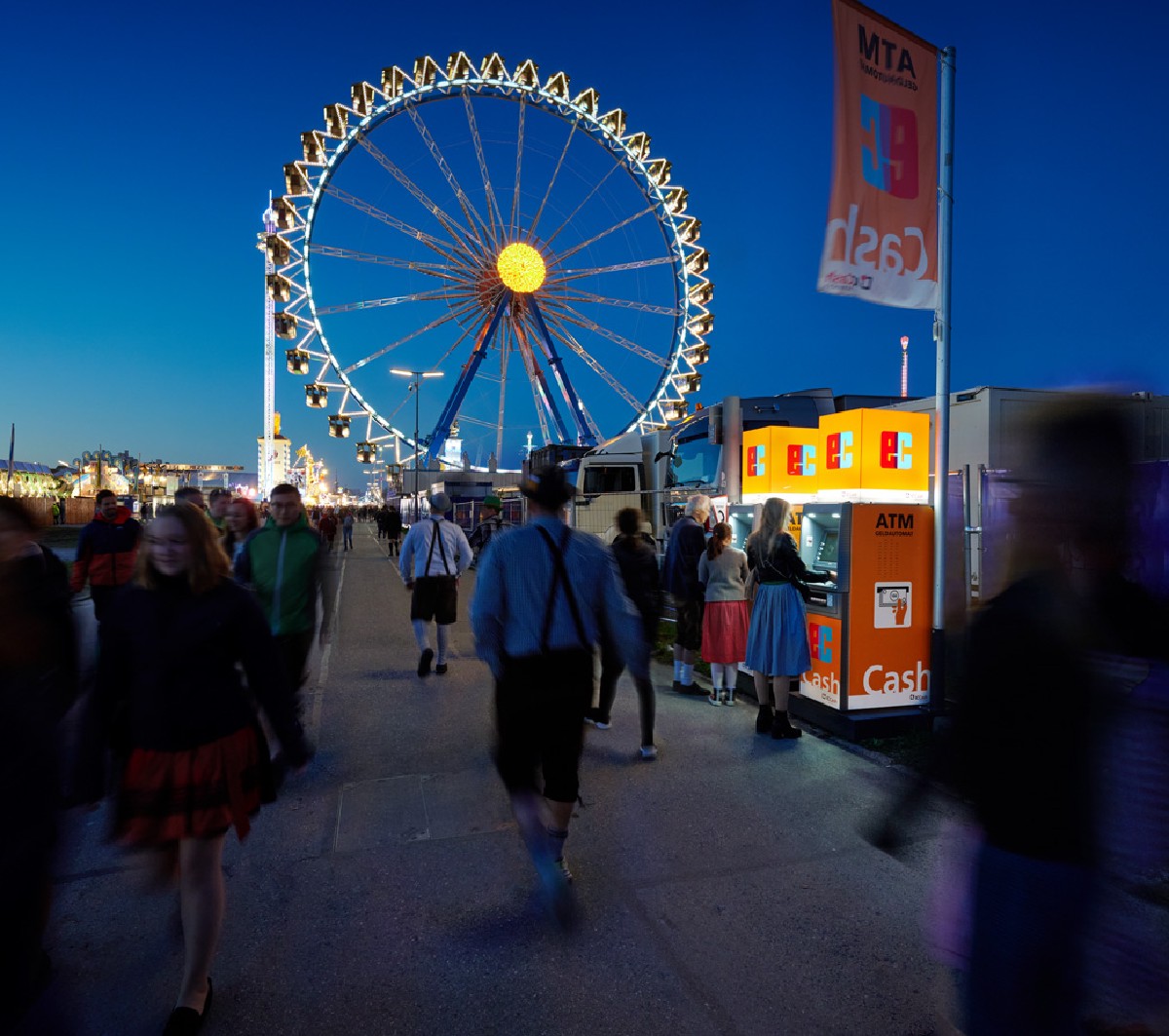 Geldautomaten vor einem Riesenrad auf einem Volksfest