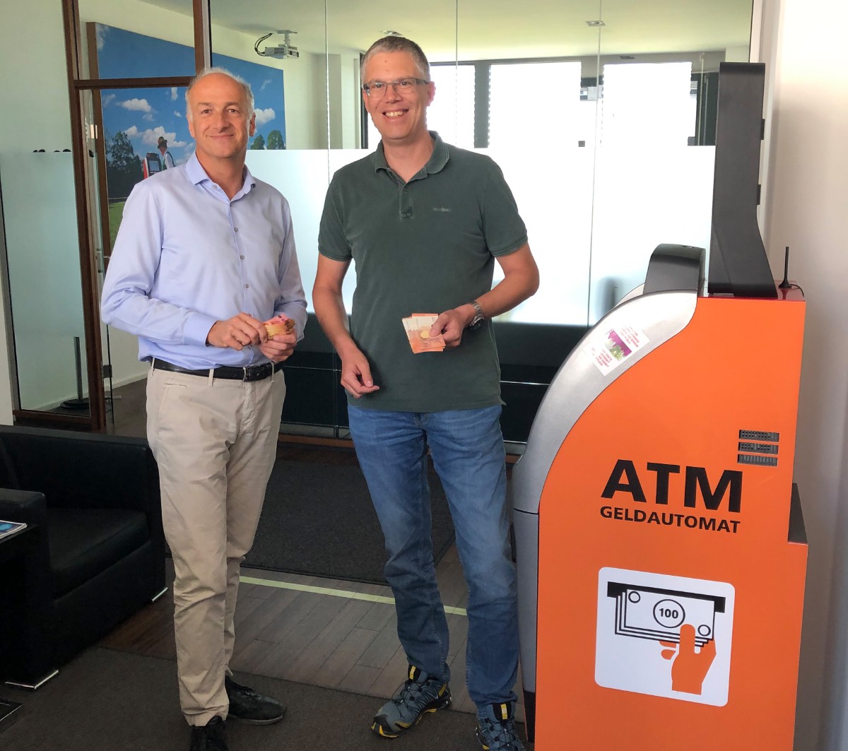 Dr. Kersten Trojanus and Marc Stückemann next to an IC Cash ATM